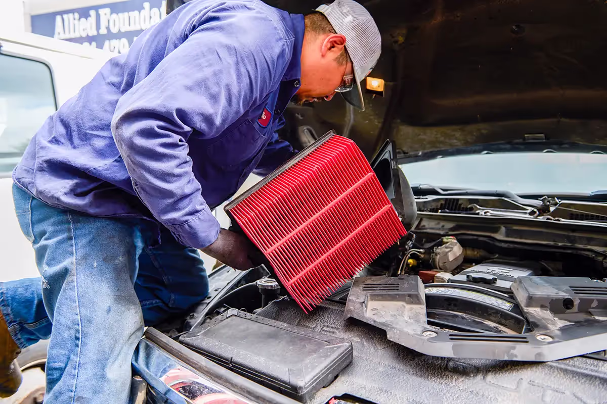 Mechanic performing preventive maintenance services on truck